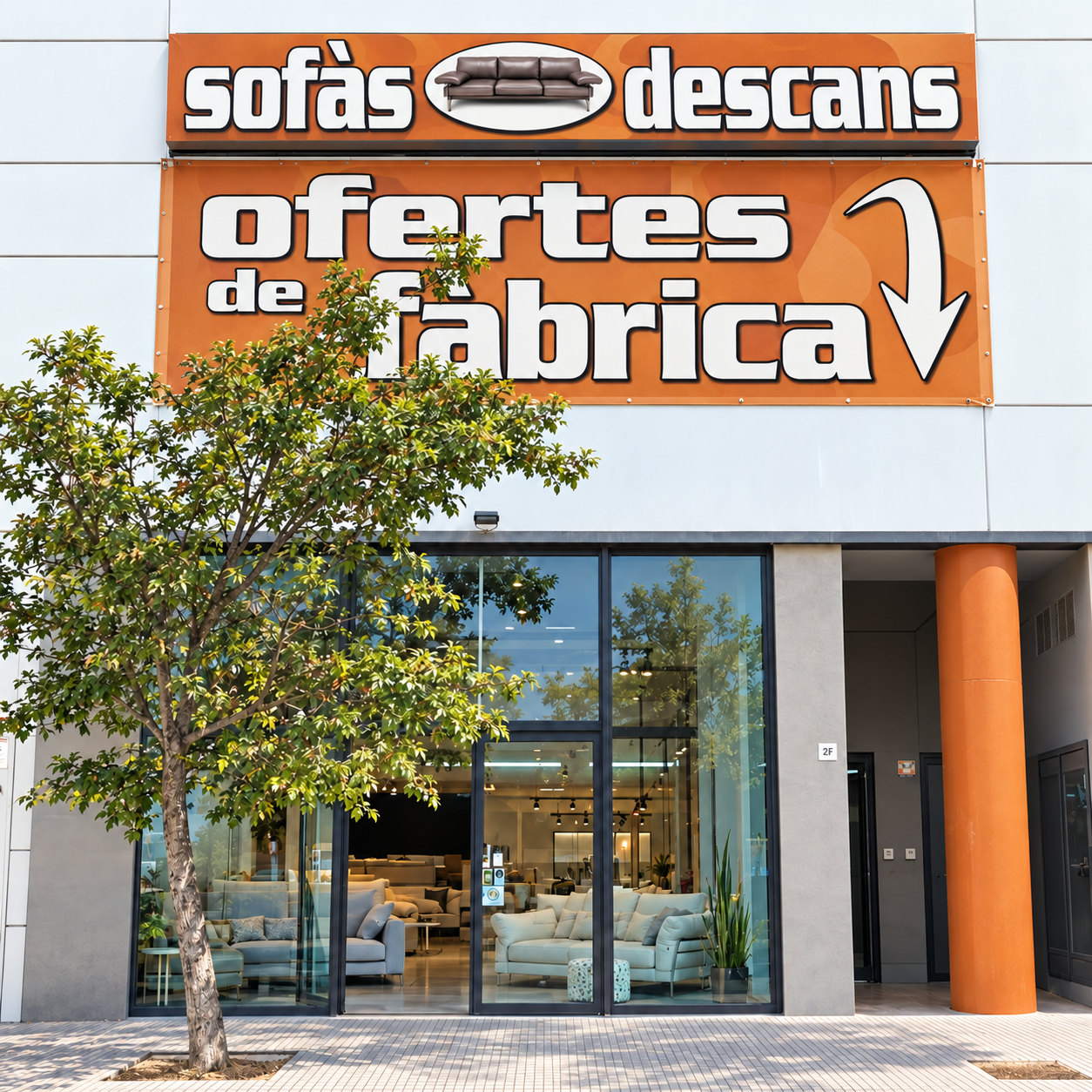 Fachada de Sofás Descans en Sant Boi, con rótulos y columna en naranja